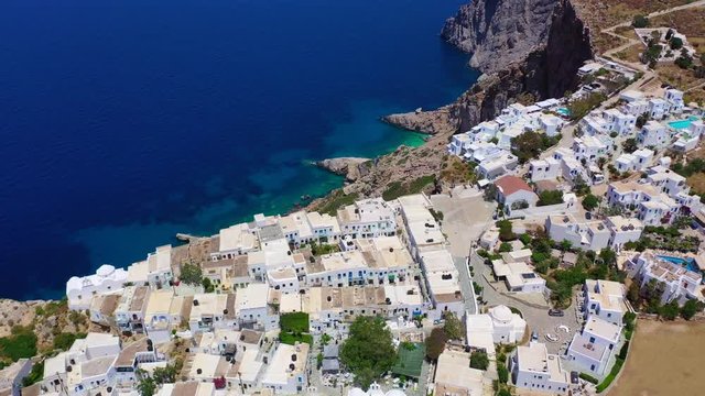 Aerial drone video of iconic and picturesque main village (chora) of Folegandros island featuring castle and built on top of steep hill overlooking the Aegean blue sea, Cyclades, Greece