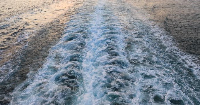 Cruise ship wake Pacific ocean sunset on water. Destination vacation travel tropical ocean sea. Caribbean cruise ship wake behind boat. Beautiful blue Caribbean Ocean water wake behind cruise ship.