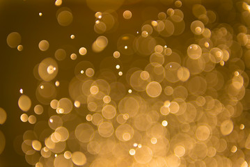 Glitter lights abstract yellow gold background. Defocused bokeh dark illustration