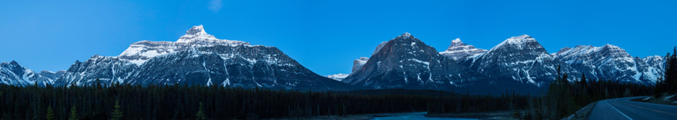 Panorama of Rocky Mountains in the moonlight along beautiful river