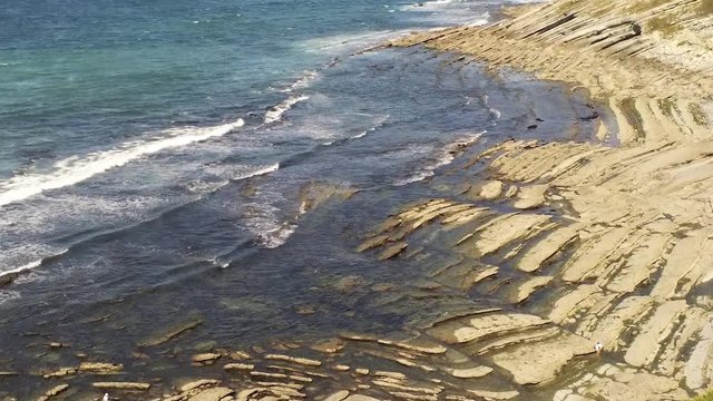 Aerial Drone Footage of waves bouncing on rocks at the beach. Beautiful blue turquoise sea atlantic ocean. Guetary, South France. Beautiful landscape in 4K.