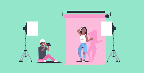 professional photographer using camera man shooting beautiful sexy african american woman model posing modern photo studio horizontal full length flat