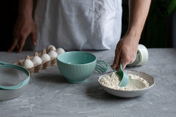 Making pancakes with chef. Chef at his workplace with cooking inventory and ingridients on a dark background.