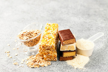 Different Energy protein bars and oatmeal bars on grey background.   Set of energy, sport, breakfast and protein bars