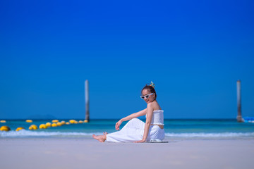 Travel and Vacation. Freedom and relax Concept. excited woman in white dress and sunglasses sit on...