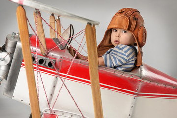 Boy in the image of a pilot playing with a plane