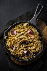 Homemade pasta with octopus on skillet