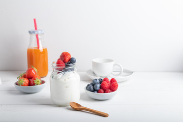 A serving of yogurt with fresh fruit on a breakfast table