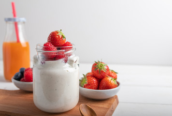 A serving of yogurt with fresh fruit on a breakfast table