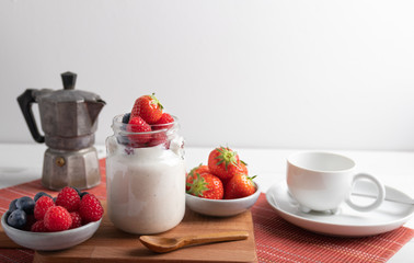 A serving of yogurt with fresh fruit on a breakfast table