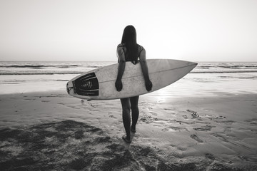 Nostalgia and remembrance photo of surfer woman in bikini go to surfing. beautiful sexy woman with surfboard on beach. black and white color tone. - obrazy, fototapety, plakaty