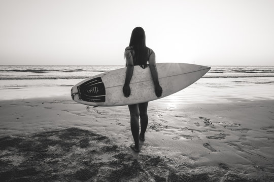 Nostalgia and remembrance photo of surfer woman in bikini go to surfing. beautiful sexy woman with surfboard on beach. black and white color tone.