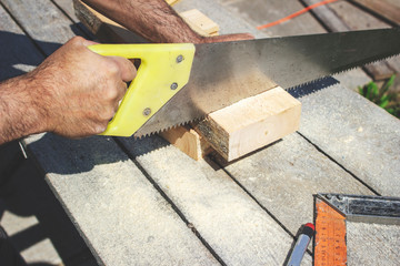 Man sawing a Board with a saw