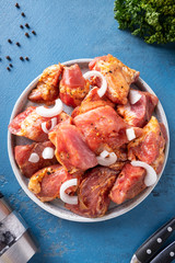 Raw marinated pork meat with spices and onion. Top view
