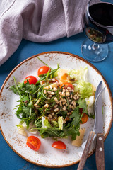 Arugula  salad with  pine nuts, tomatoes and cheese. Healthy food. Top view. Closeup
