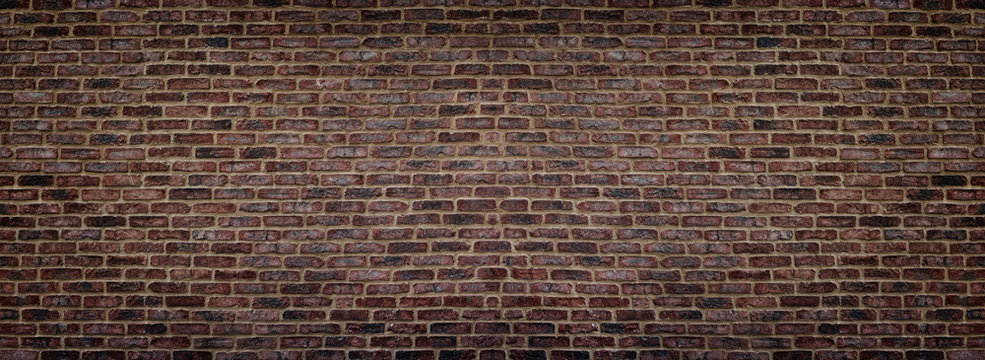 Wide red shabby brick wall texture. Old masonry panorama. Dark rough brickwork panoramic background