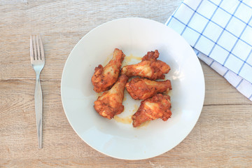Chicken wings spicy in dish on wooden table.