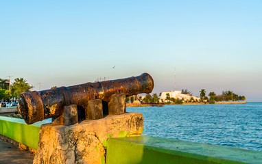 Fototapeta na wymiar Old rusty cannon at the seaside promenade in Chetumal, Mexico