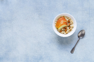 Healthy breakfast Oatmeal porridge with apples and nuts served in a bowl.