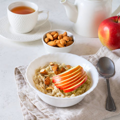Healthy breakfast Oatmeal porridge with apples and nuts served in a bowl.