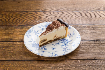 slice of Tiramisu cake isolated on wooden background