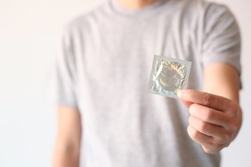 Condom ready to use in male hand,  safe sex concept on the bed Prevent infection and Contraceptives control the birth rate or safe prophylactic. World AIDS Day . Safe sex concept.Leave space for text.