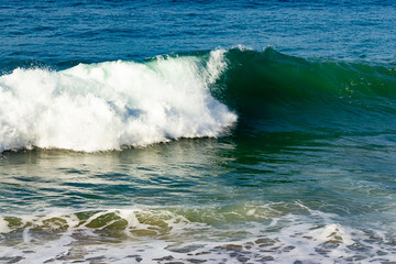 breaking wave on ocean, refleted in the water with open ocean