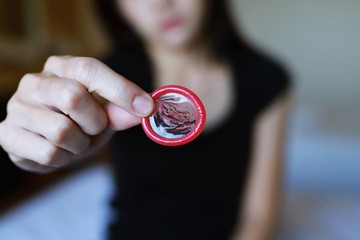 Close-ups of women showing women condoms