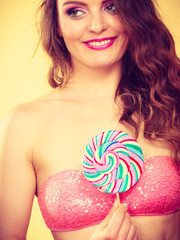 Woman holding colorful lollipop candy in hand.
