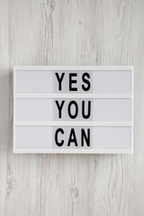 'Yes you can' words on a modern board over white wooden surface, top view. Overhead, from above. Flat lay. Close-up.