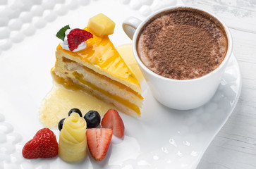 delicious cake with strawberries and blueberries on a white plate with a Cup of coffee