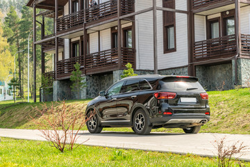 Black SUV near the holiday homes in the resort in the mountains