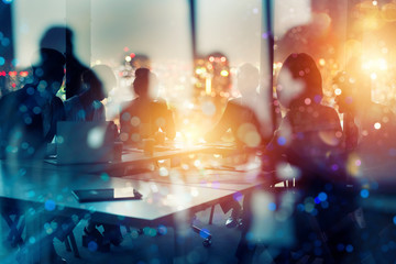Businessmen that work together in office at night. Concept of teamwork and partnership. double exposure