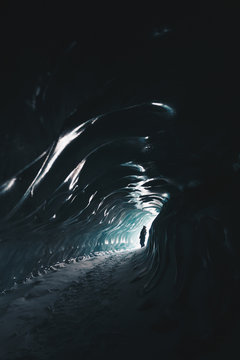 silhouette of a man standing inside an ice cave on Svalbard. 