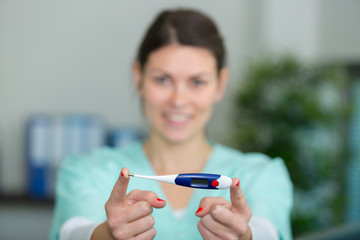 female nurse showing thermometer