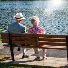 Senioren sitzen auf Bank im Park am See