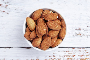 A small bowl with almond at white background	