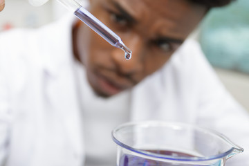 biochemist with flask petri sitting at a desk