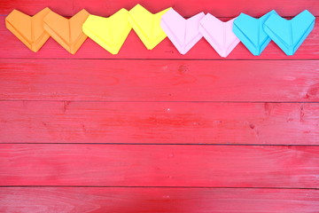 close up colorful heart on red wood background