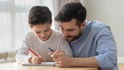 Young dad drawing together with preschooler son