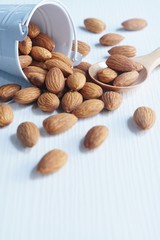 Almond nut in white on white wooden table background