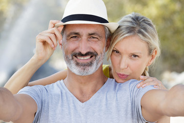 smiling man and woman sitting in cuddles outside