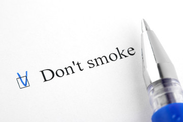 Obraz premium Don't smoke. Filling in the questionnaire, documents. The checkboxes are filled with a black pen on a white background. Questionnaire, survey.