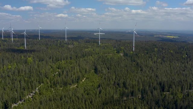 Pan to the right across wind turbines in the Black Forest