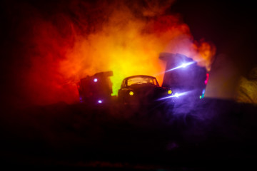 Police car chasing a car at night with fog background. 911 Emergency response police car speeding to scene of crime. Selective focus