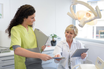 female dental assistant giving information to dentist