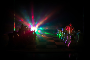 Chess board game concept of business ideas and competition. Chess figures on a dark background with smoke and fog.