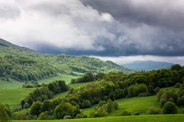 Fototapeta na wymiar Stormy weather with dramatic rainy clouds over green peaks in Carpathian Mountains, Bieszczady,Poland