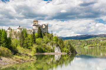 Naklejka premium Niedzica castle on cliff at Czorsztyn lake in Poland. Green landscape overview