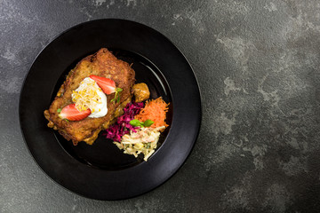 Potato pancake with meat and salad, restaurant dish